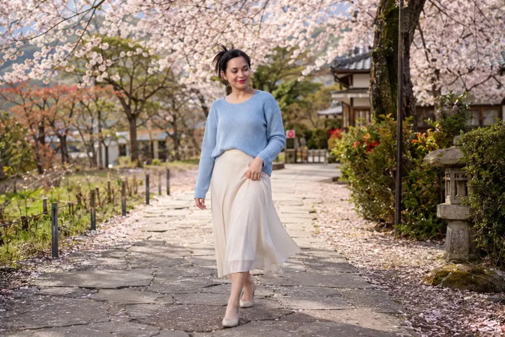Mulher caminhando sob cerejeiras floridas em um parque no Japão