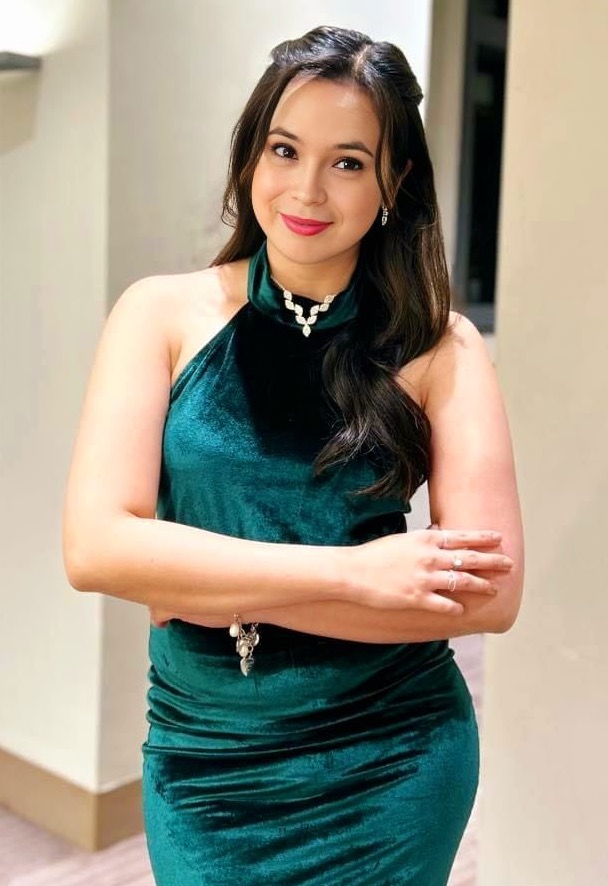 Patrícia Akamine sorrindo em ambiente leve e feminino