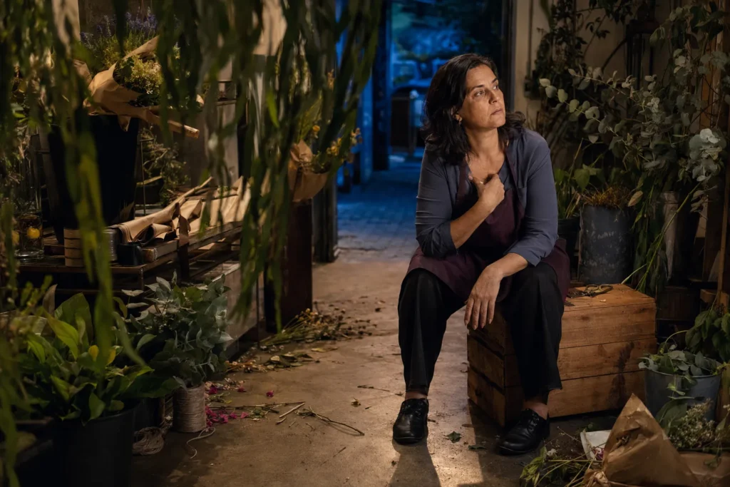 Mulher fazendo uma pausa emocional em uma floricultura depois de um dia cansativo